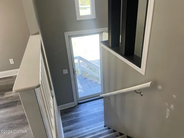 a view of an entryway with wooden floor