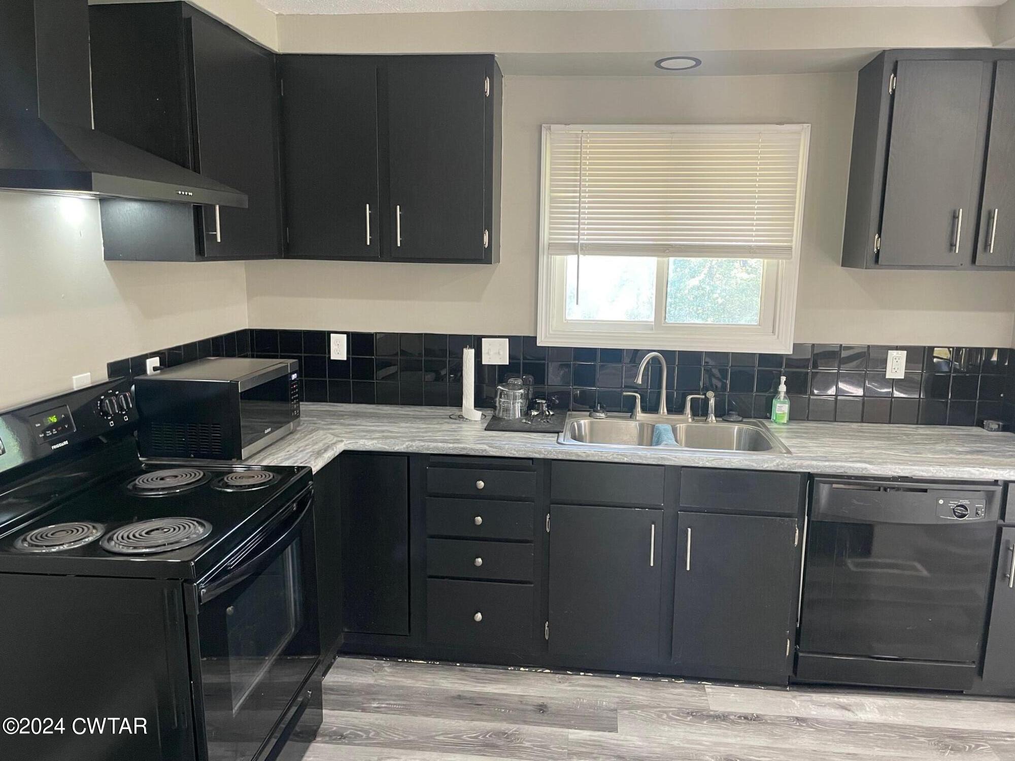 113 Ebenezer Road Mercer, TN 38392 - Photo 6 of 36 a kitchen with granite countertop a sink cabinets and stainless steel appliances