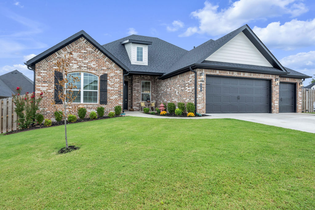 418 Casella Street Springdale, AR 72762 - Photo 1 of 34 Brick exterior with contrasting dark trim, multi-car garage, dormer window, and mature landscaping