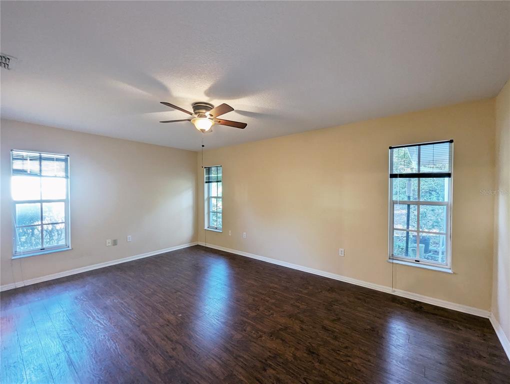 3 Graytwig Court West Homosassa, FL 34446 - Photo 18 of 41 an empty room with wooden floor chandelier fan and windows