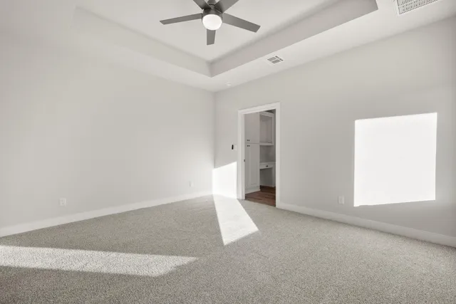 an empty room with a ceiling fan and a window