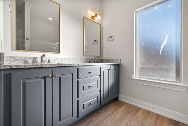 a bathroom with a granite countertop sink and a mirror