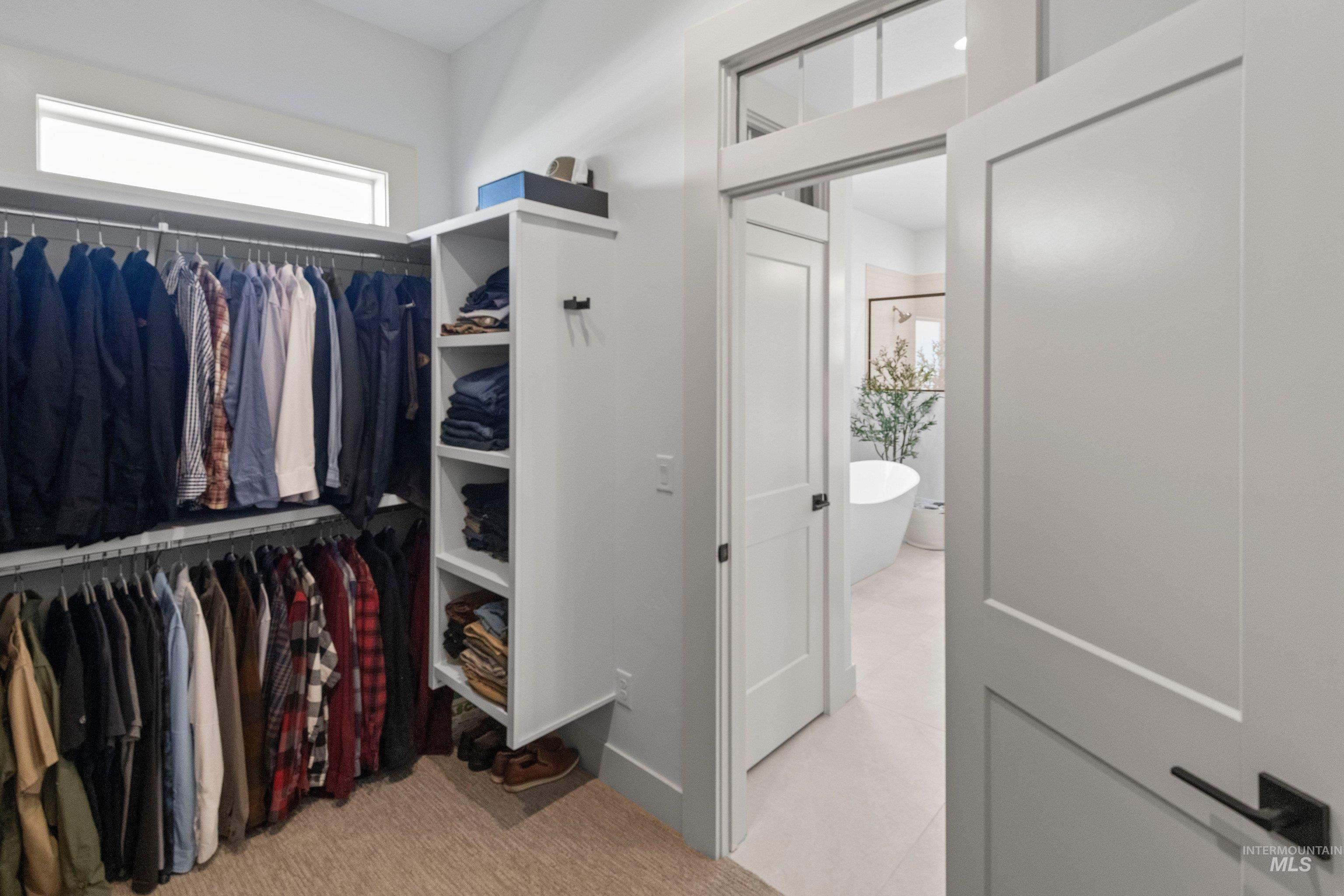 24990 Belgian Way Middleton, ID 83644 - Photo 28 of 50 Walk-in closet with built-in shelving, dual-level hanging rods, and a high transom window