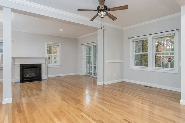 a view of an empty room with a window and fireplace