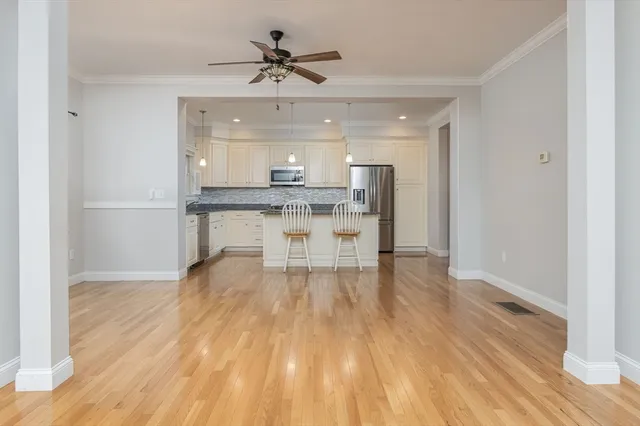 a view of a kitchen with a wooden floor and stainless steel appliances