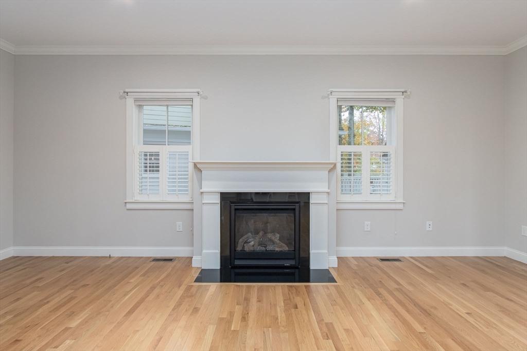 21 A Blacksmith Row, Unit 21 Groton, MA 01450 - Photo 13 of 42 a living room with a fireplace and wooden floor