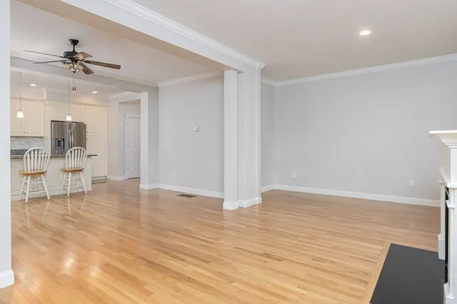 a view of an empty room and a kitchen