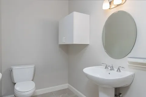 a bathroom with a sink toilet and a mirror