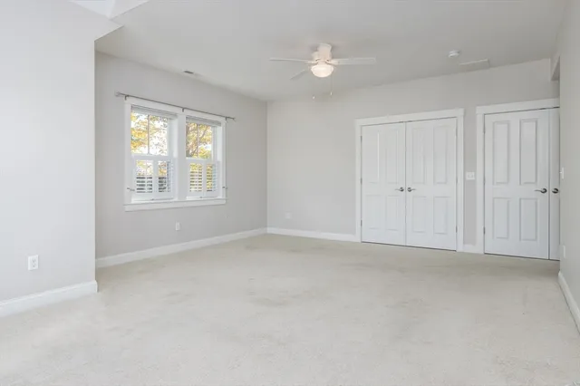an empty room with windows and closet