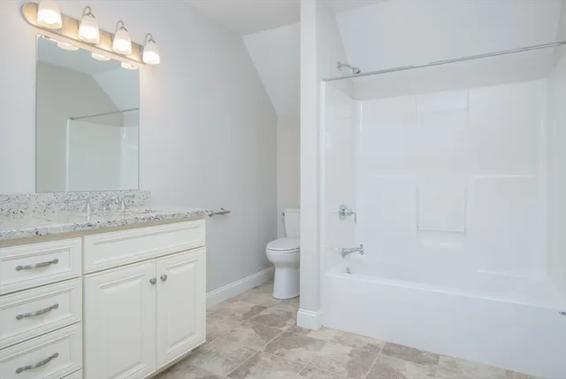 a bathroom with a granite countertop sink a toilet and shower
