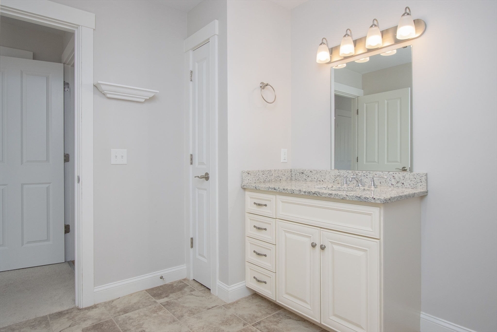 21 A Blacksmith Row, Unit 21 Groton, MA 01450 - Photo 27 of 42 a bathroom with a granite countertop sink and a mirror