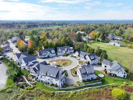 an aerial view of a house with a garden and lake view