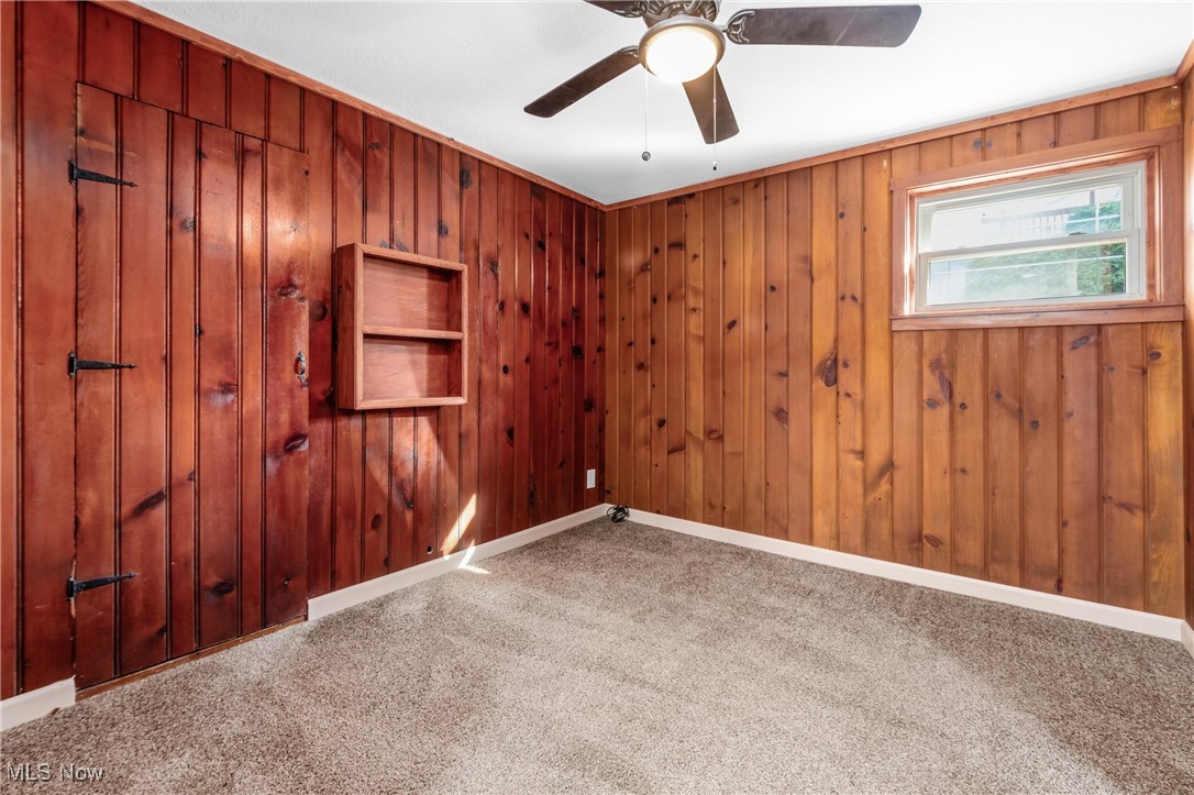 724 Garden Road Zanesville, OH 43701 - Photo 18 of 22 Carpeted spare room featuring wooden walls and baseboards