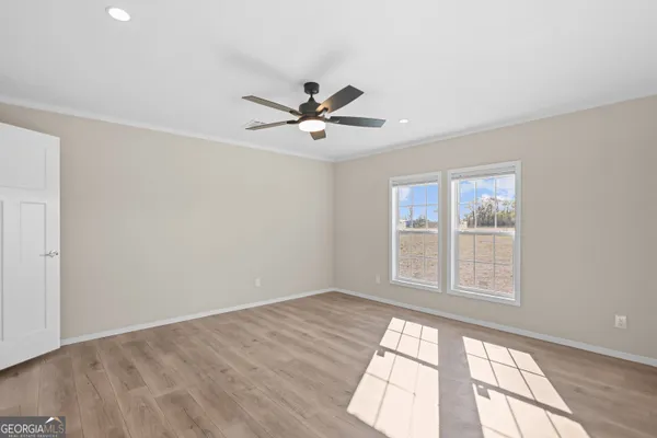 a view of a big room with wooden floor and windows