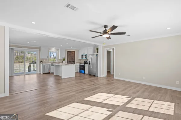 a view of a living room a kitchen and a wooden floor