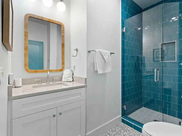 a bathroom with a granite countertop toilet sink and mirror