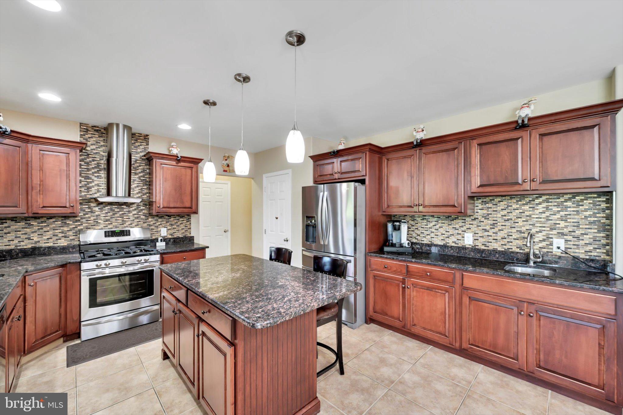 118 Connecticut Avenue Sinking Spring, PA 19608 - Photo 15 of 61 a kitchen with stainless steel appliances granite countertop a stove top oven a sink and dishwasher a refrigerator with wooden cabinets