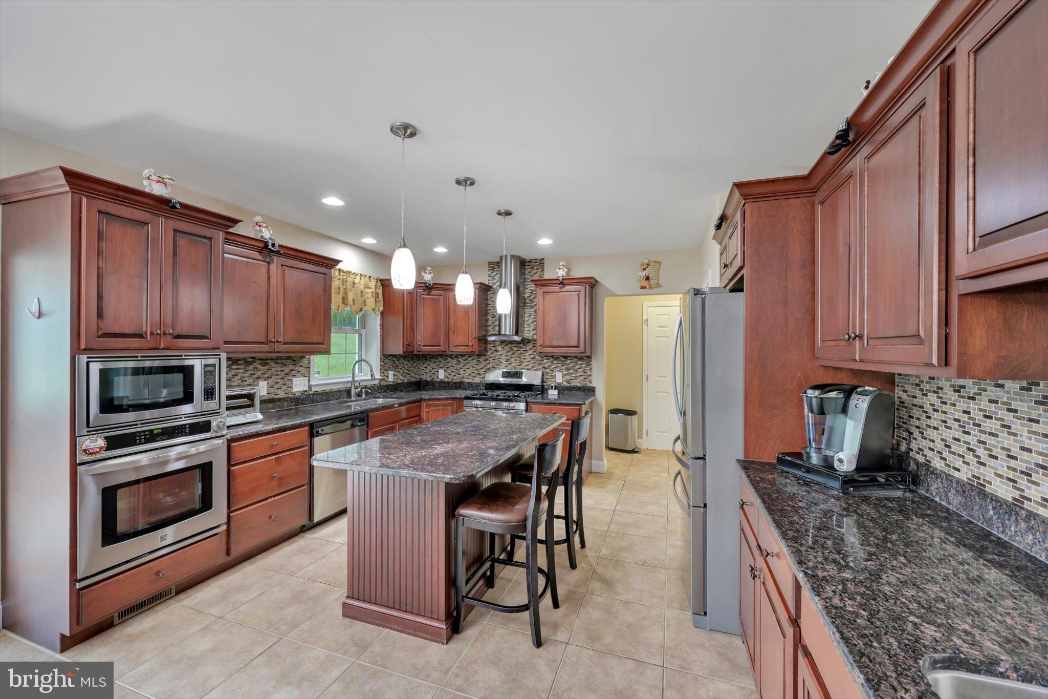 118 Connecticut Avenue Sinking Spring, PA 19608 - Photo 16 of 61 a kitchen with stainless steel appliances granite countertop a stove top oven a sink dishwasher and a refrigerator with wooden cabinets