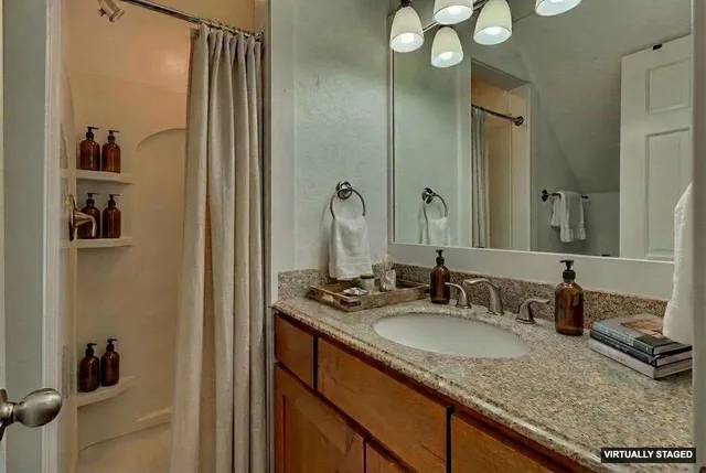 a bathroom with a granite countertop sink and a mirror
