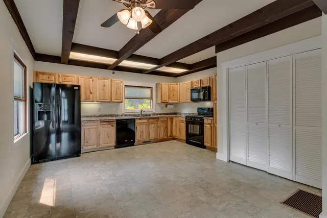 a kitchen with stainless steel appliances granite countertop a refrigerator and a sink