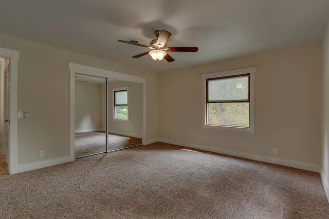 an empty room with fan and windows