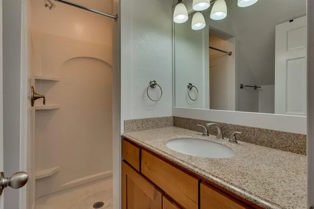 a bathroom with a granite countertop sink and a mirror