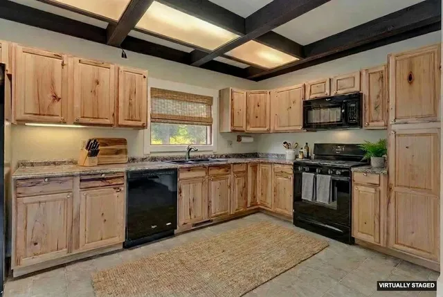 a kitchen with granite countertop a refrigerator stove top oven a sink and dishwasher