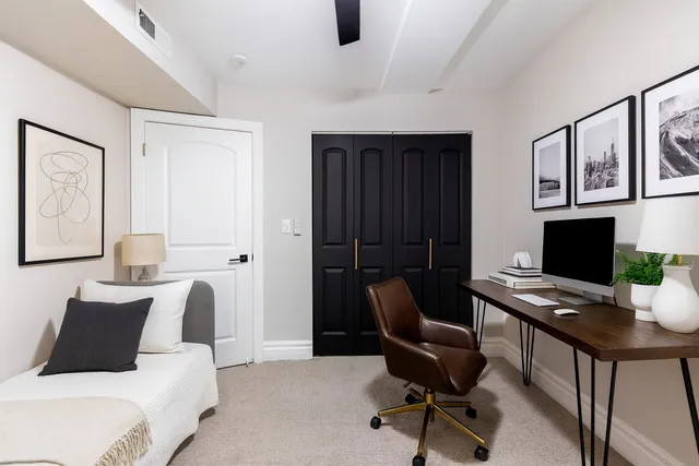 a view of a workspace with furniture and a window