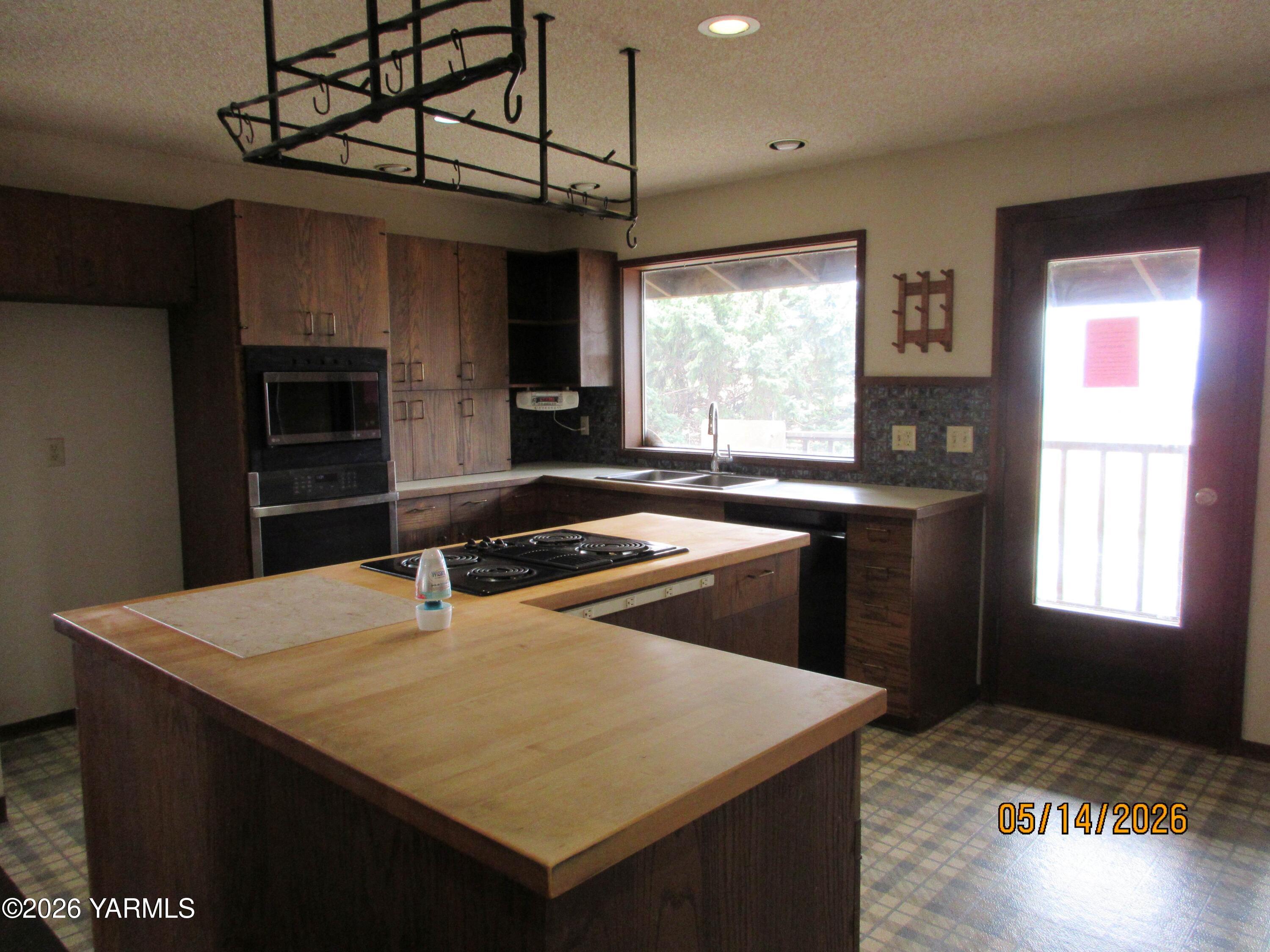 1303 Nightingale Road Wapato, WA 98951 - Photo 7 of 26 a kitchen with kitchen island a sink table and chairs