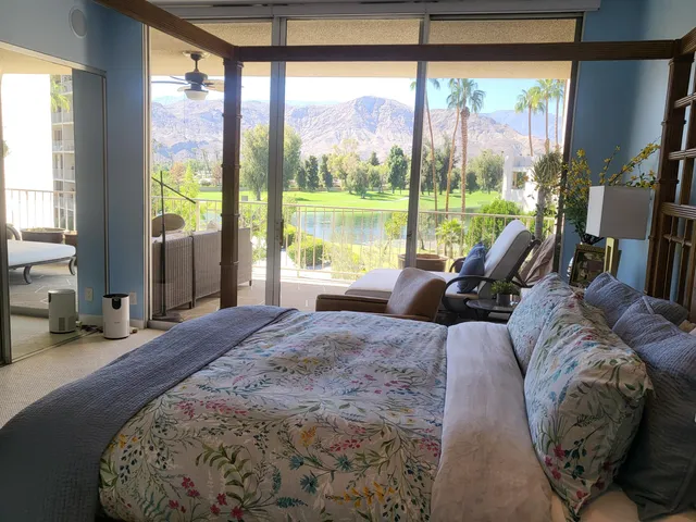 a bed sitting in a bedroom next to a large window