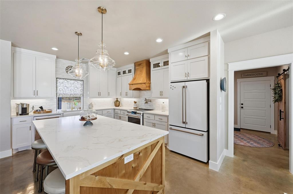 350 Rolling Rnch Boulevard Alvord, TX 76225 - Photo 20 of 30 a kitchen with kitchen island a refrigerator stove microwave and cabinets