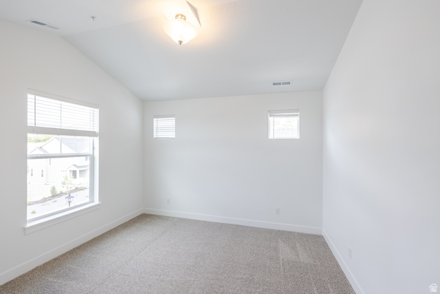 675 West 4500th South, Unit P301 Mapleton, UT 84664 - Photo 10 of 16 Spacious room featuring vaulted ceilings, a large window with horizontal blinds, two smaller windows, and light neutral carpeting