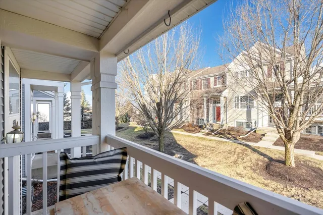 a view of a house with a snow on the wall and a wooden fence