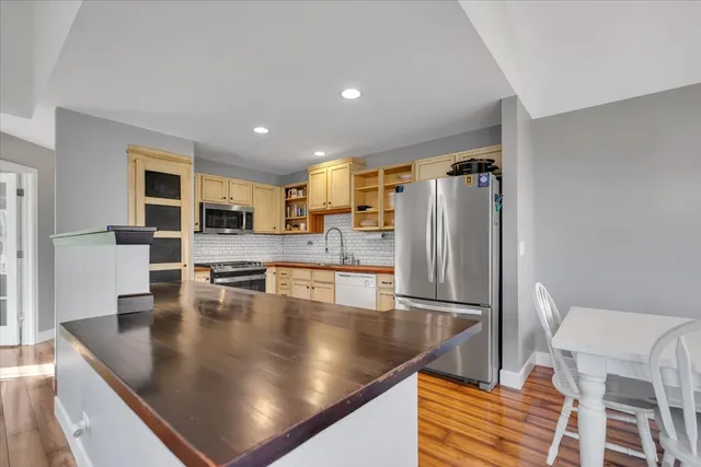 a kitchen with stainless steel appliances granite countertop a refrigerator a stove and a sink with granite countertops