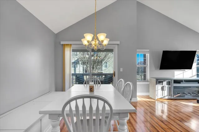a view of a dining room with furniture a chandelier and wooden floor