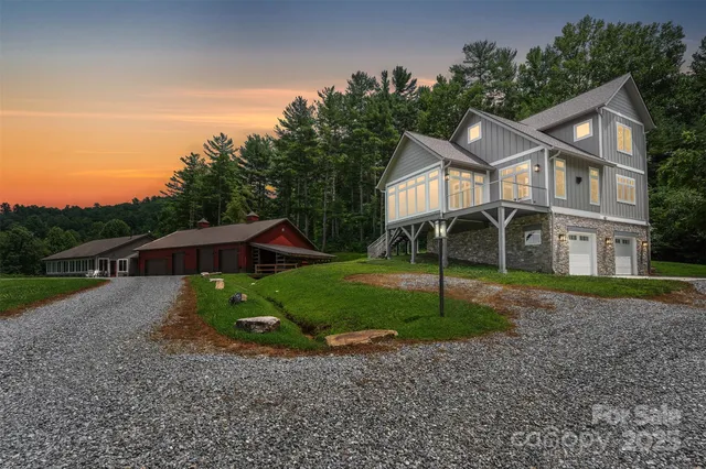 a view of a house with a yard and large trees