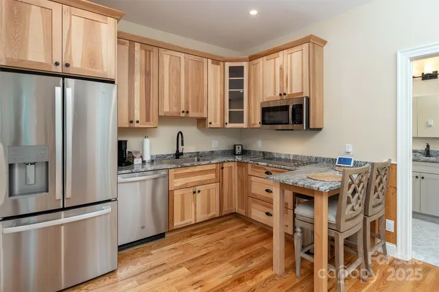 a kitchen with stainless steel appliances granite countertop a stove a sink refrigerator and a microwave