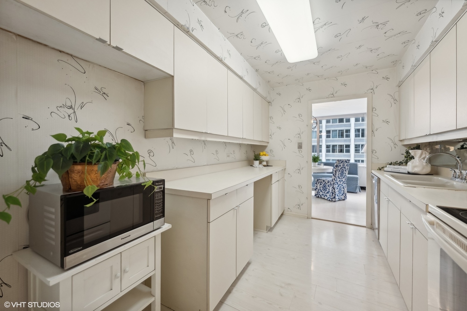 4250 North Marine Drive, Unit 2115 Chicago, IL 60613 - Photo 11 of 24 a kitchen with stainless steel appliances a white stove top oven and cabinets