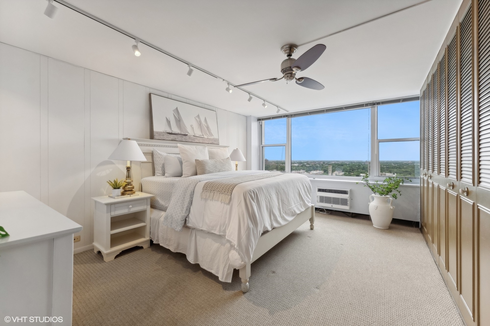 4250 North Marine Drive, Unit 2115 Chicago, IL 60613 - Photo 13 of 24 a bedroom with a bed couch chandelier and a window