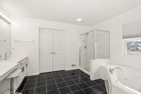 a bathroom with a bathtub a mirror a sink and a shower