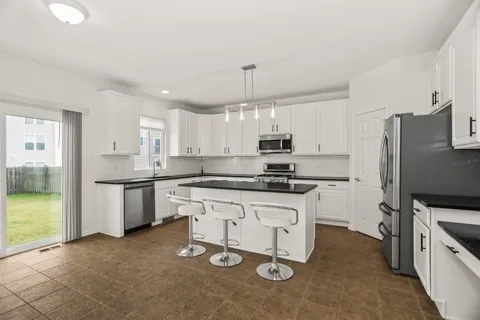 a kitchen with granite countertop a sink stove and refrigerator