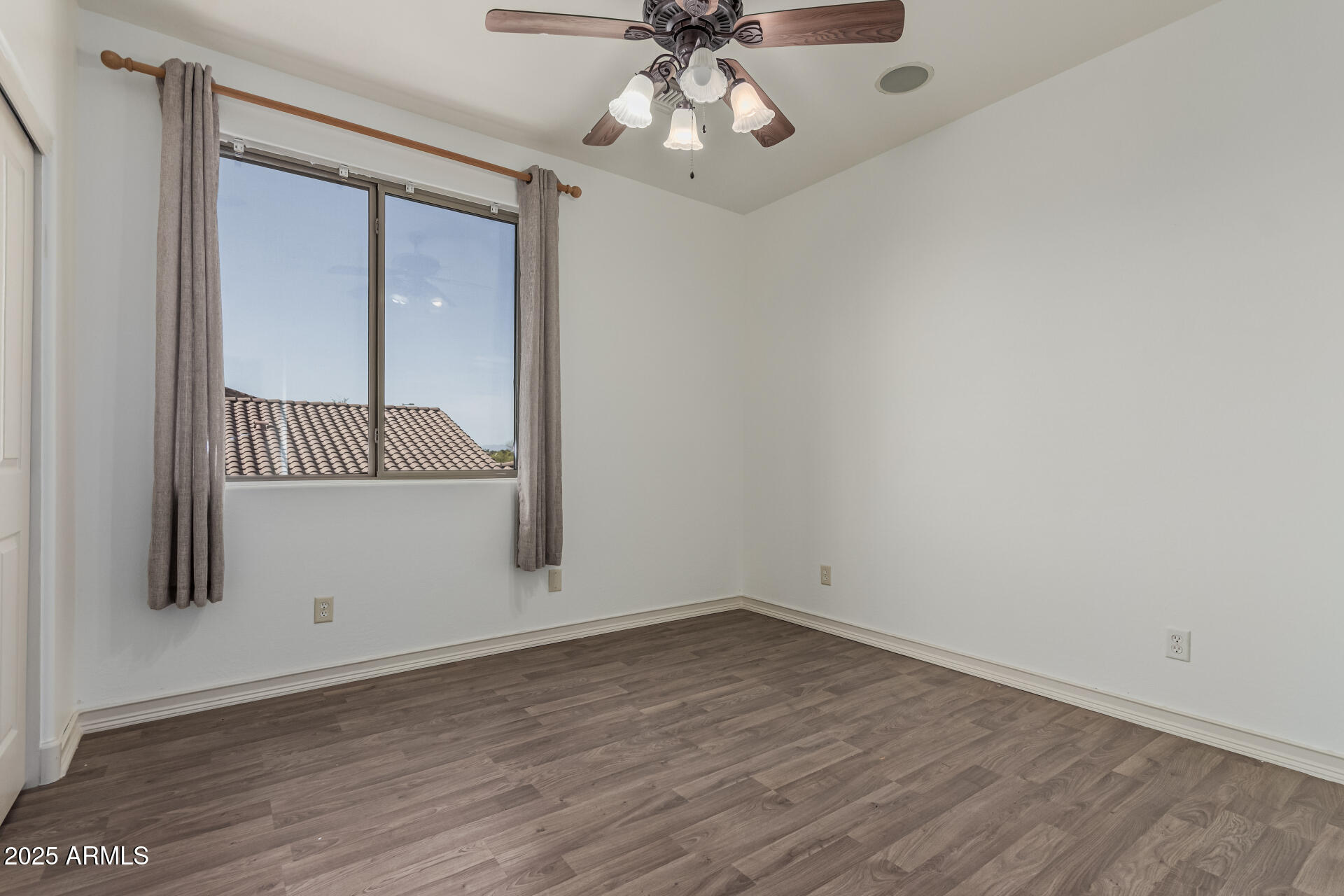 5752 South Crossbow Place Chandler, AZ 85249 - Photo 34 of 51 an empty room with wooden floor fan and windows