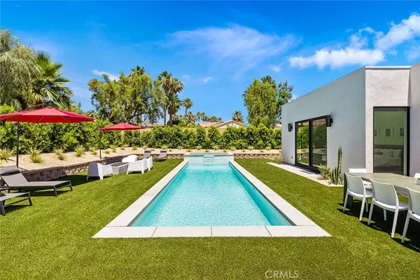 a view of an house with swimming pool and sitting area