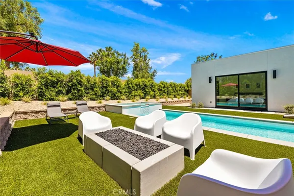 a view of swimming pool with outdoor seating and yard in back