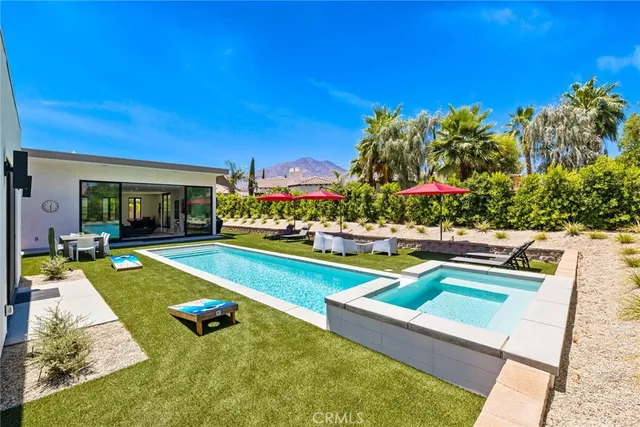 a view of an house with swimming pool and chairs