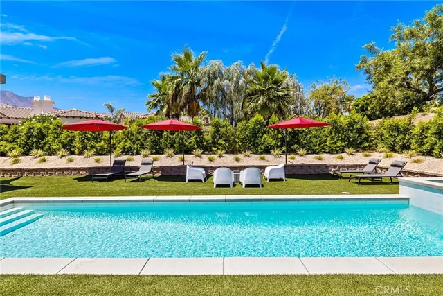 a view of swimming pool with a yard and potted plants