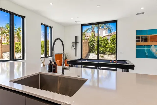 a living room with stainless steel appliances kitchen island a table and chairs in it