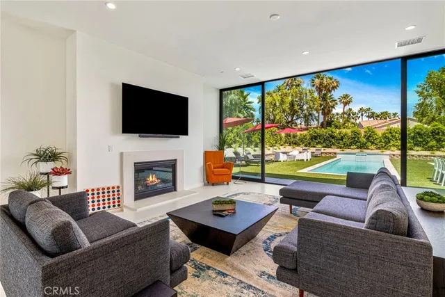 a living room with furniture a flat screen tv and a floor to ceiling window