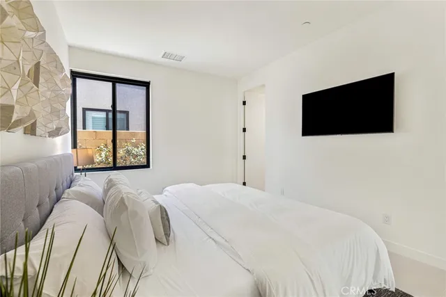 a spacious bedroom with a large bed and a large window