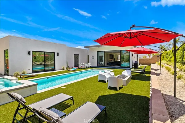 a view of a house with swimming pool and sitting area